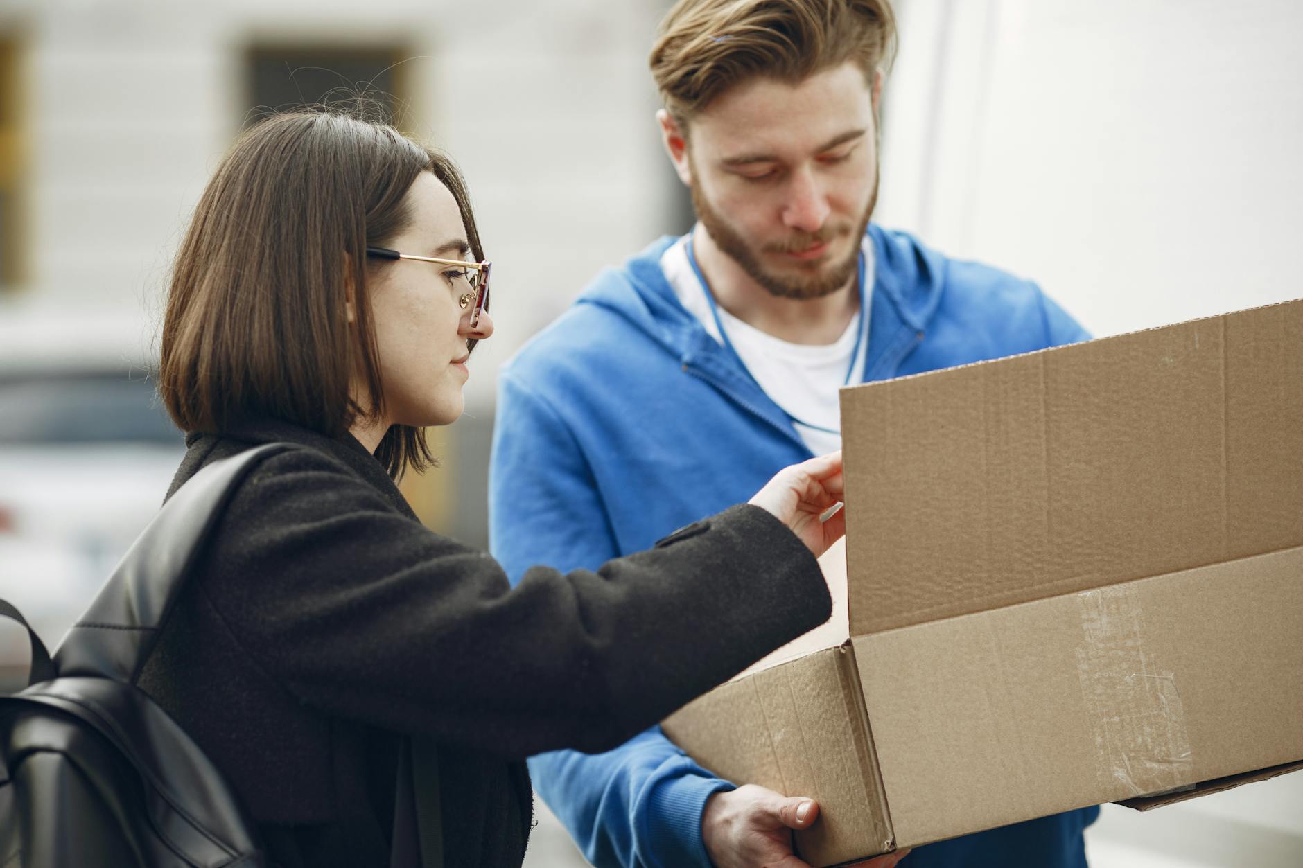 Kurier przekazujący paczkę kobiecie na ulicy w mieście