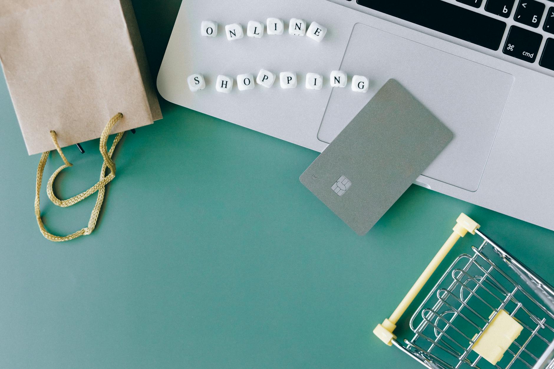 Jak zwrócić towar, gdy sklep zmienił regulamin po zakupie: co się liczy? Laptop, karta płatnicza i mini wózek symbolizujące zakupy online