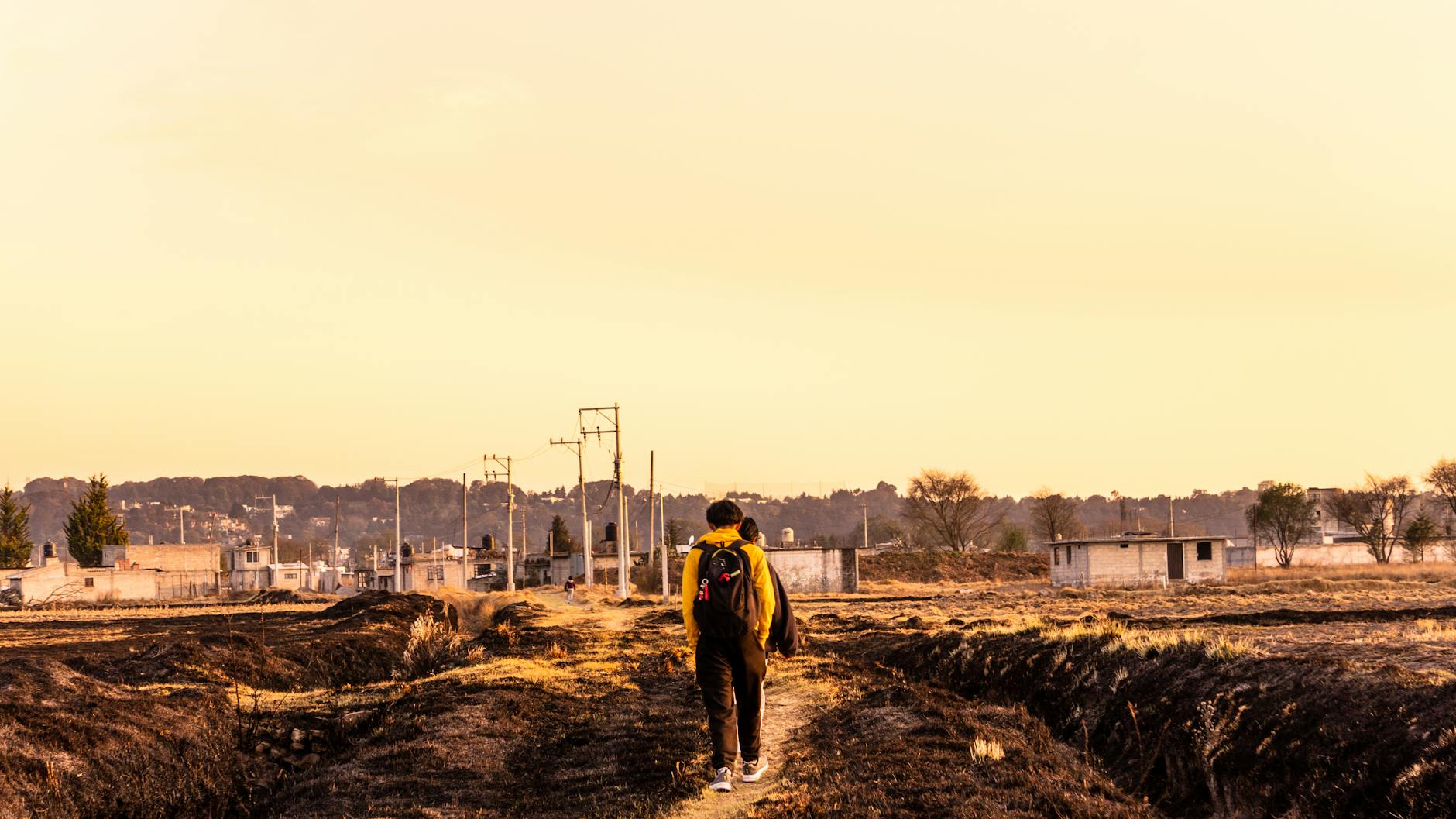 Podróżnik z plecakiem idzie wiejską drogą w Meksyku o zachodzie słońca