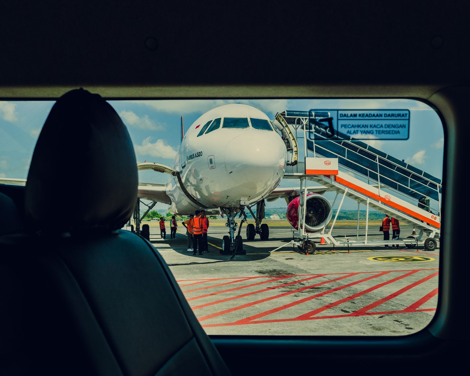 Samolot widziany z auta na płycie lotniska podczas obsługi ground crew