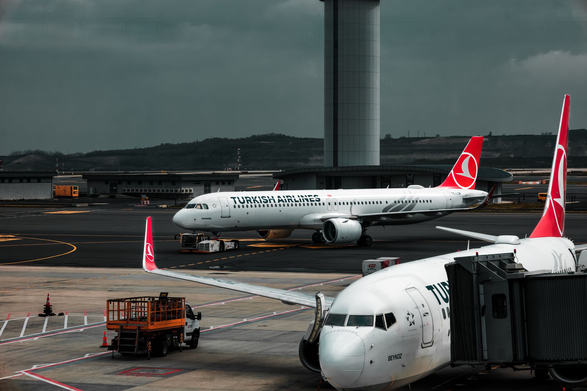 Samoloty Turkish Airlines stojące na płycie lotniska z wieżą kontrolną